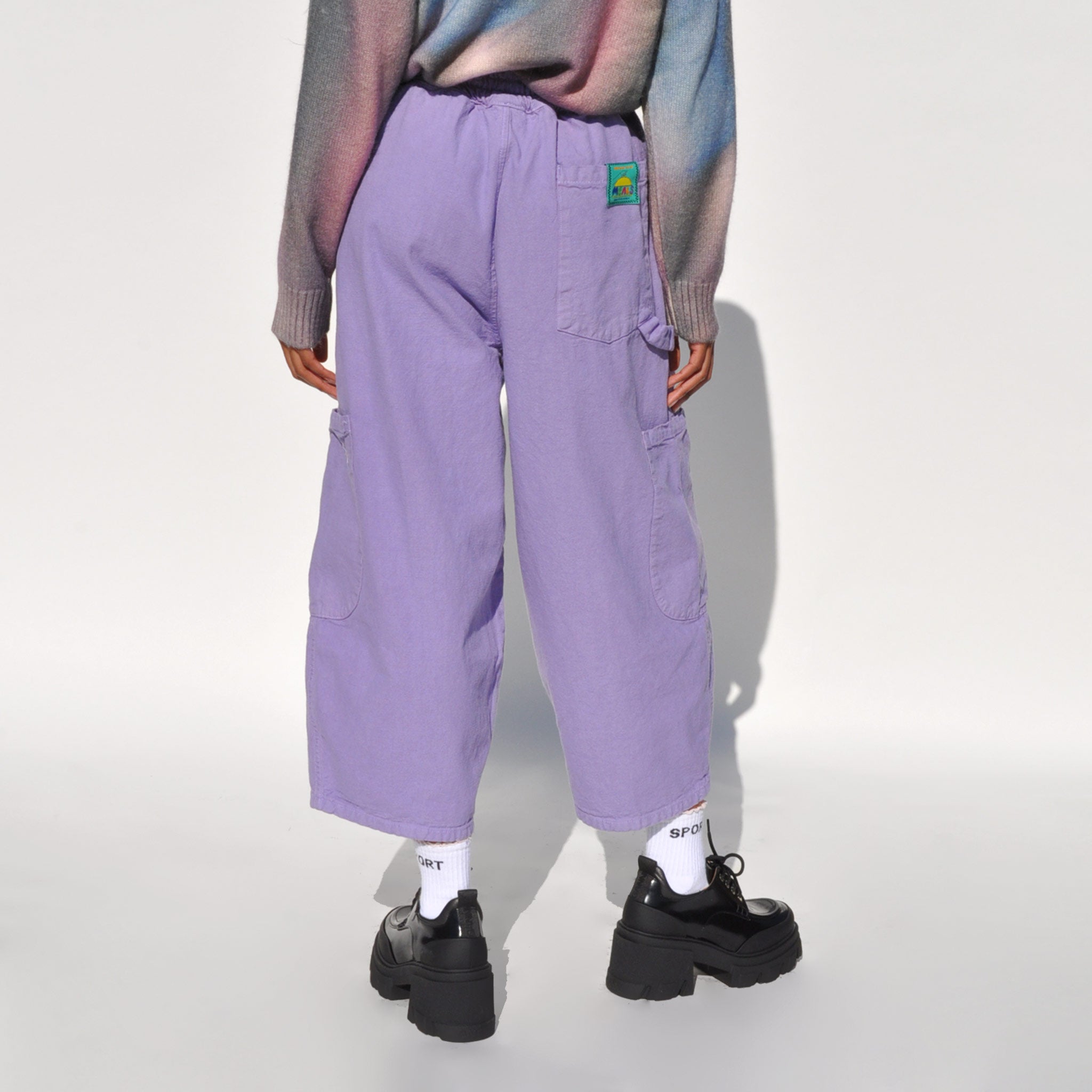 Back photo of a model wearing the chef pants in lavender by Meals.