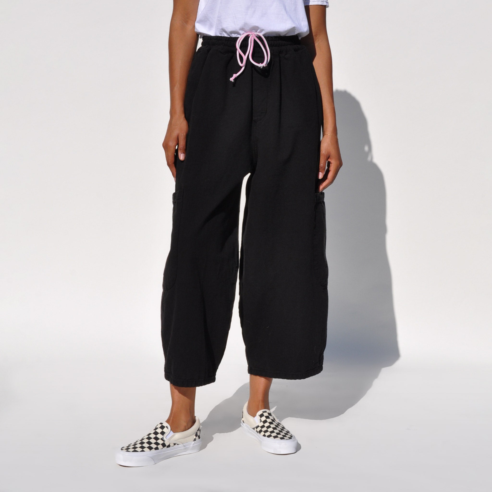 Close photo of a model wearing the chef pants in lack licorice by Meals.