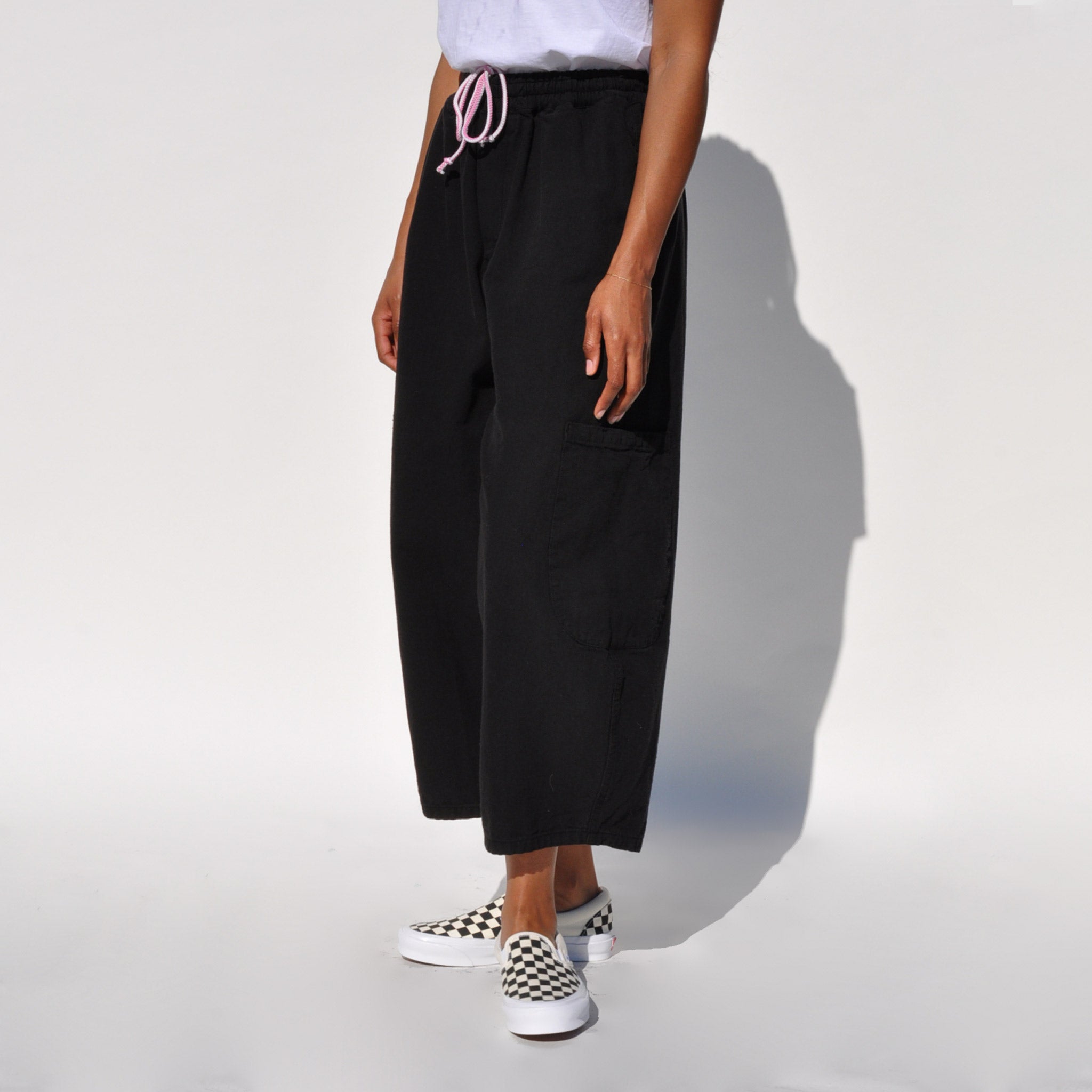 Side photo of a model wearing the chef pants in lack licorice by Meals.