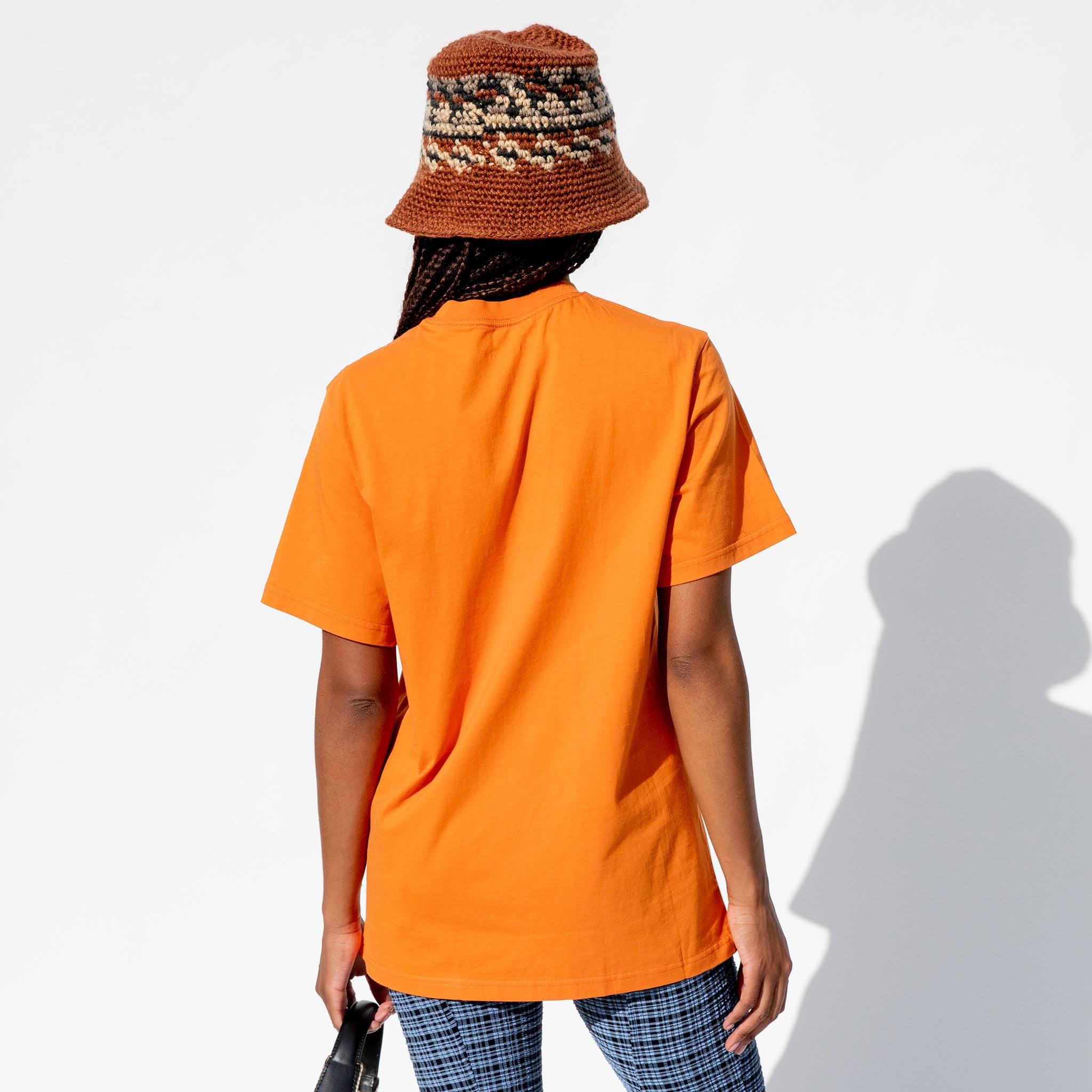 Back half body photo of model wearing the Classic S/S T-shirt - Orange Speakers.