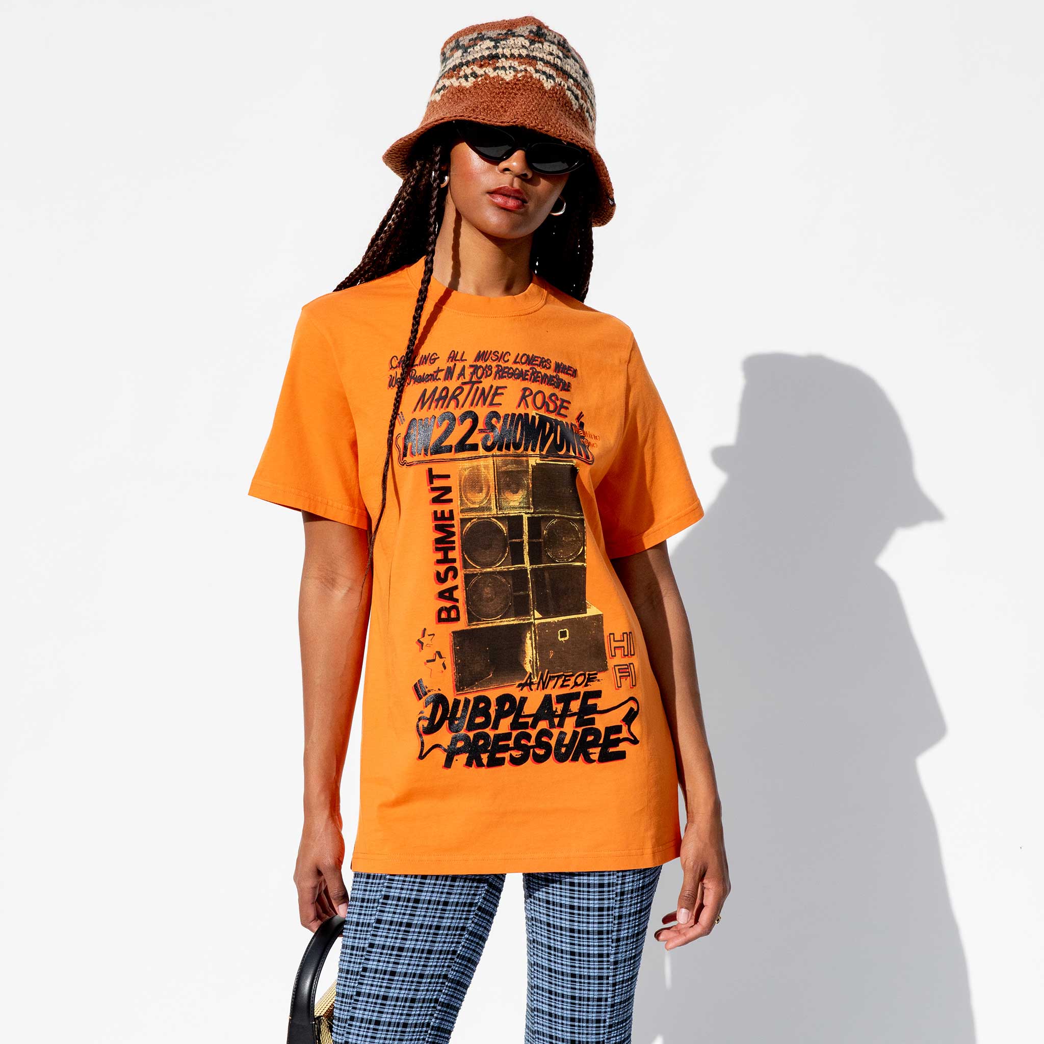 Close half body photo of model wearing the Classic S/S T-shirt - Orange Speakers.