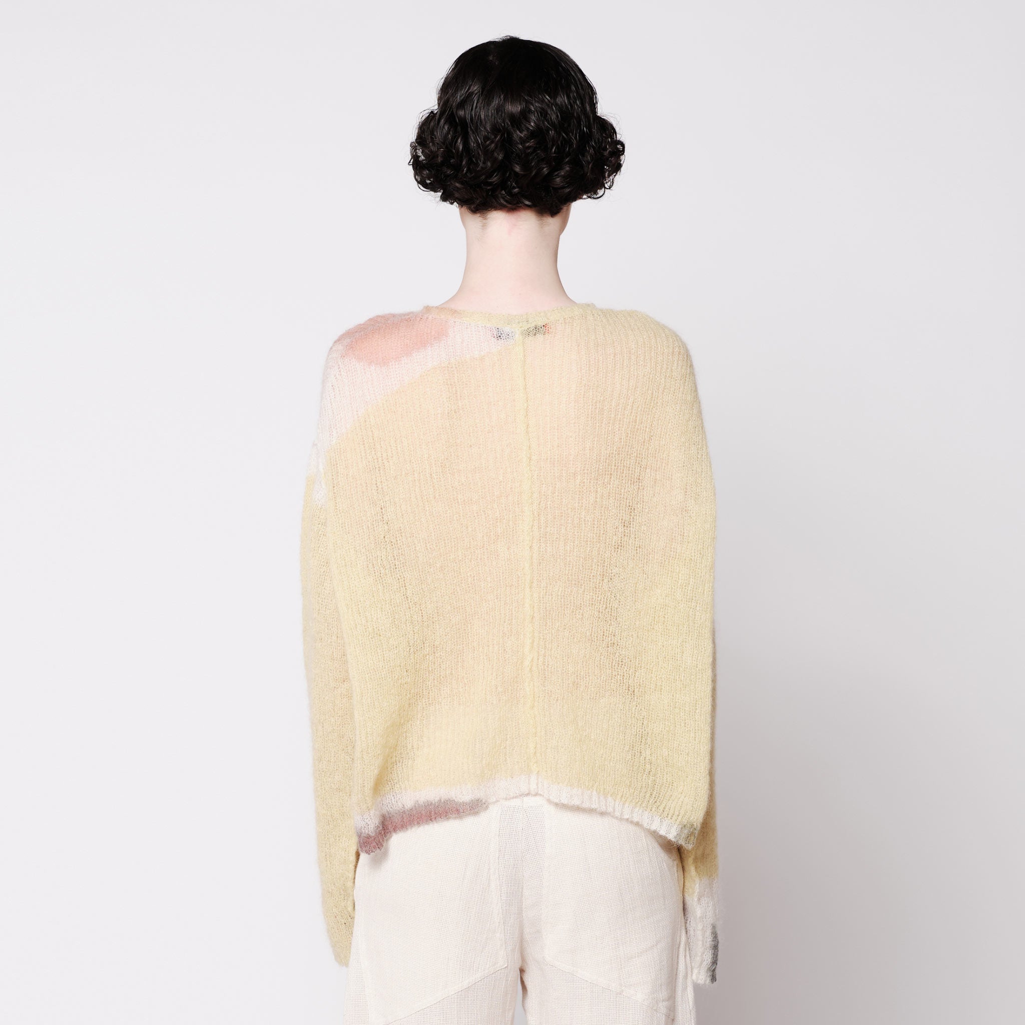 Back half body photo of model wearing the Composition Sweater - Sand.