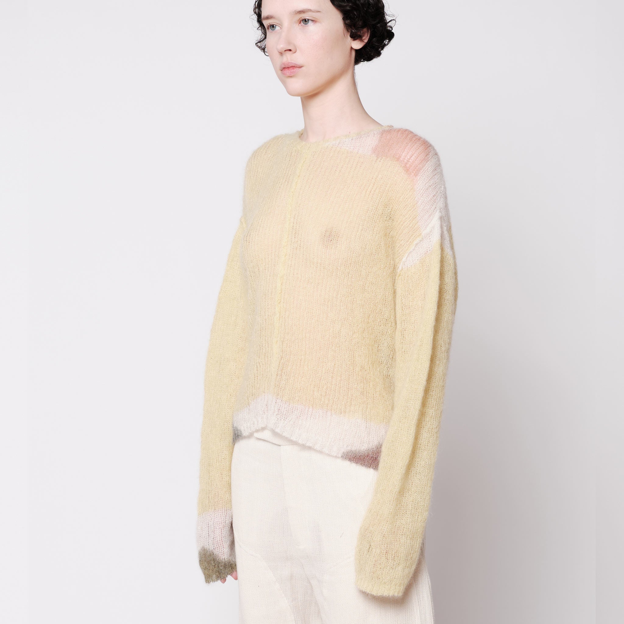Side half body photo of model wearing the Composition Sweater - Sand.