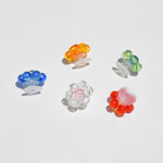 Photo displays croc charms available at LCD. Flower shaped charms of various colors on white backdrop.
