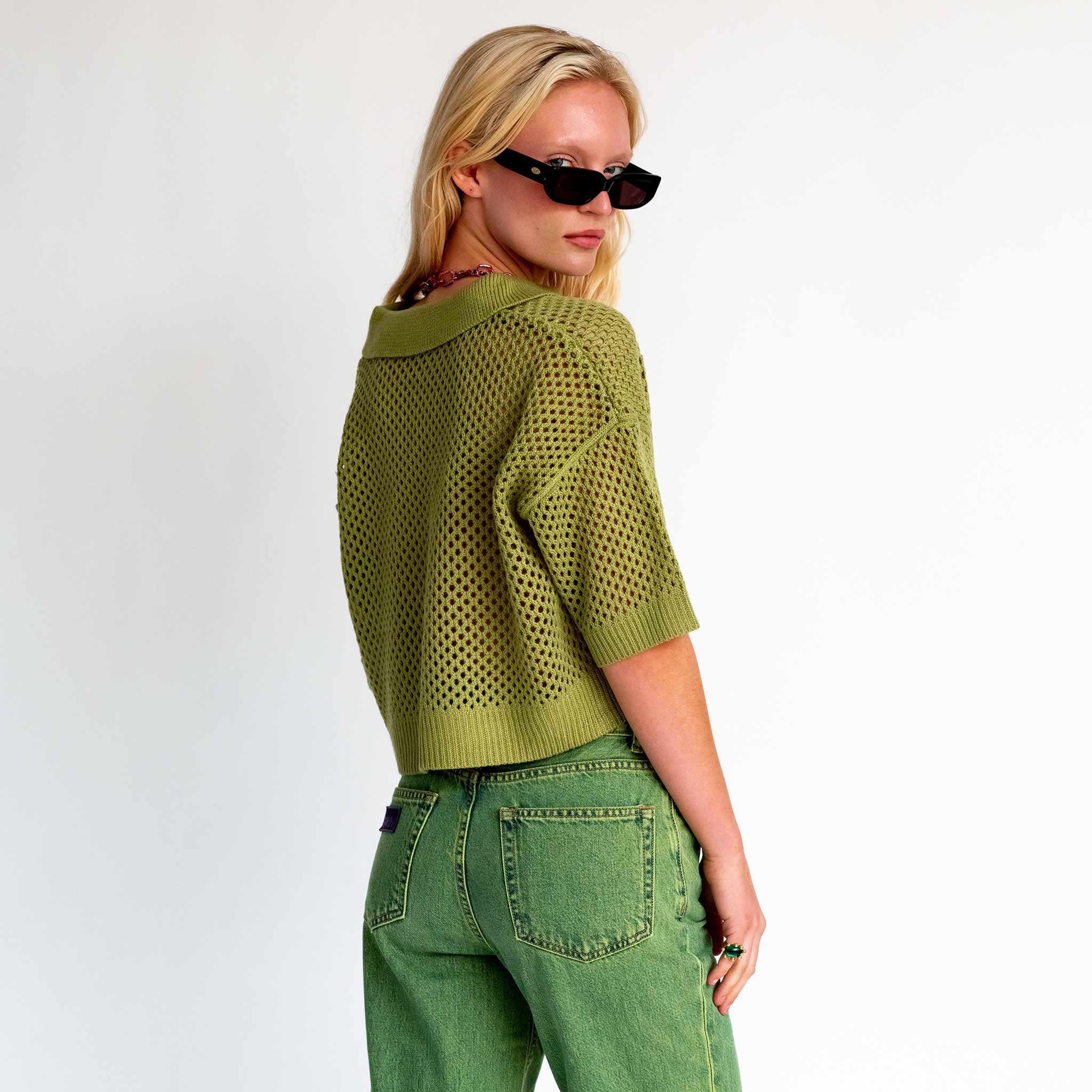 Back half body detail photo of model wearing the Crochet Polo Top - Leaf. 
