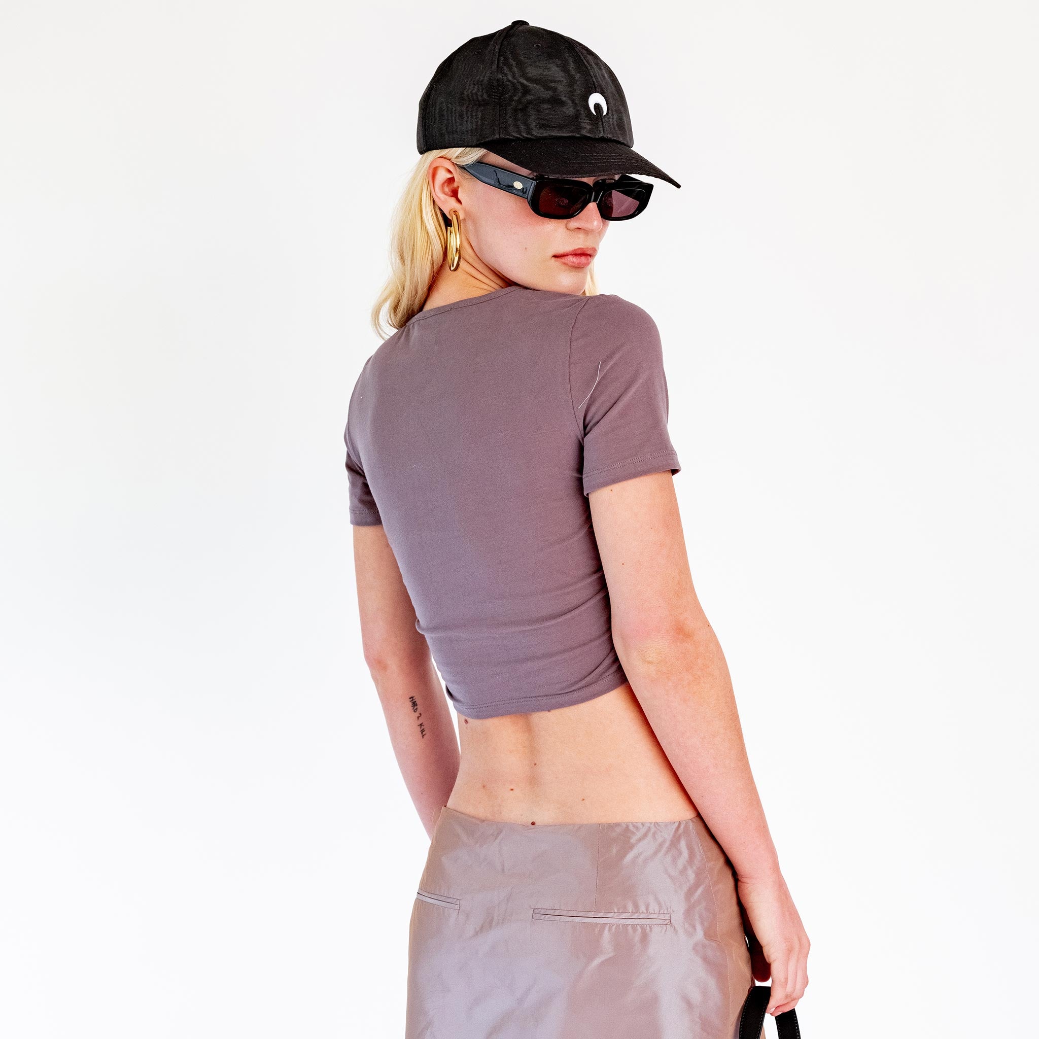Back half body photo of model wearing the Cropped Scoop Neck Ruched Tee - Charcoal.