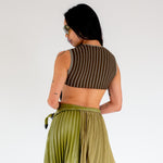Back photo of model wearing the Fluted Tank - Lichen. a cropped ribbed knit tank with cutout back detail.