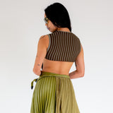 Back photo of model wearing the Fluted Tank - Lichen. a cropped ribbed knit tank with cutout back detail.