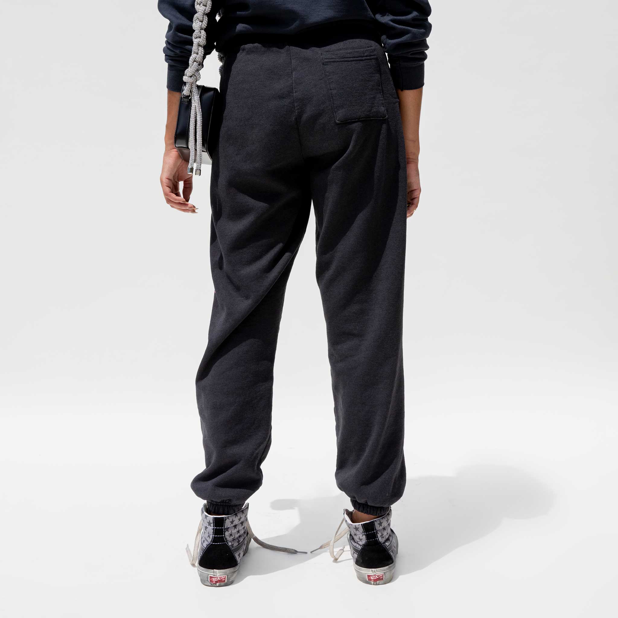 Back detail photo of model wearing the Vintage Washed LCD10 Motto Sweatpants. 