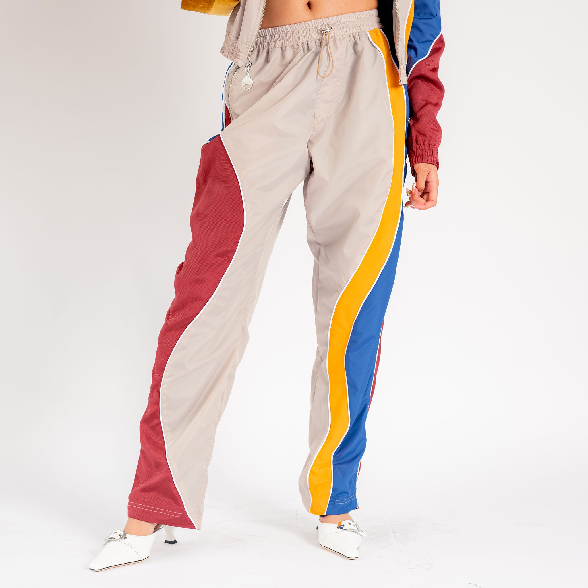 Front half body photo of model wearing the Idi Track Pant - Beige.