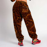 Back view of a model wearing the Aries x Juicy Couture Psysnake Velour Sweatpants, with a brown and black snake print.