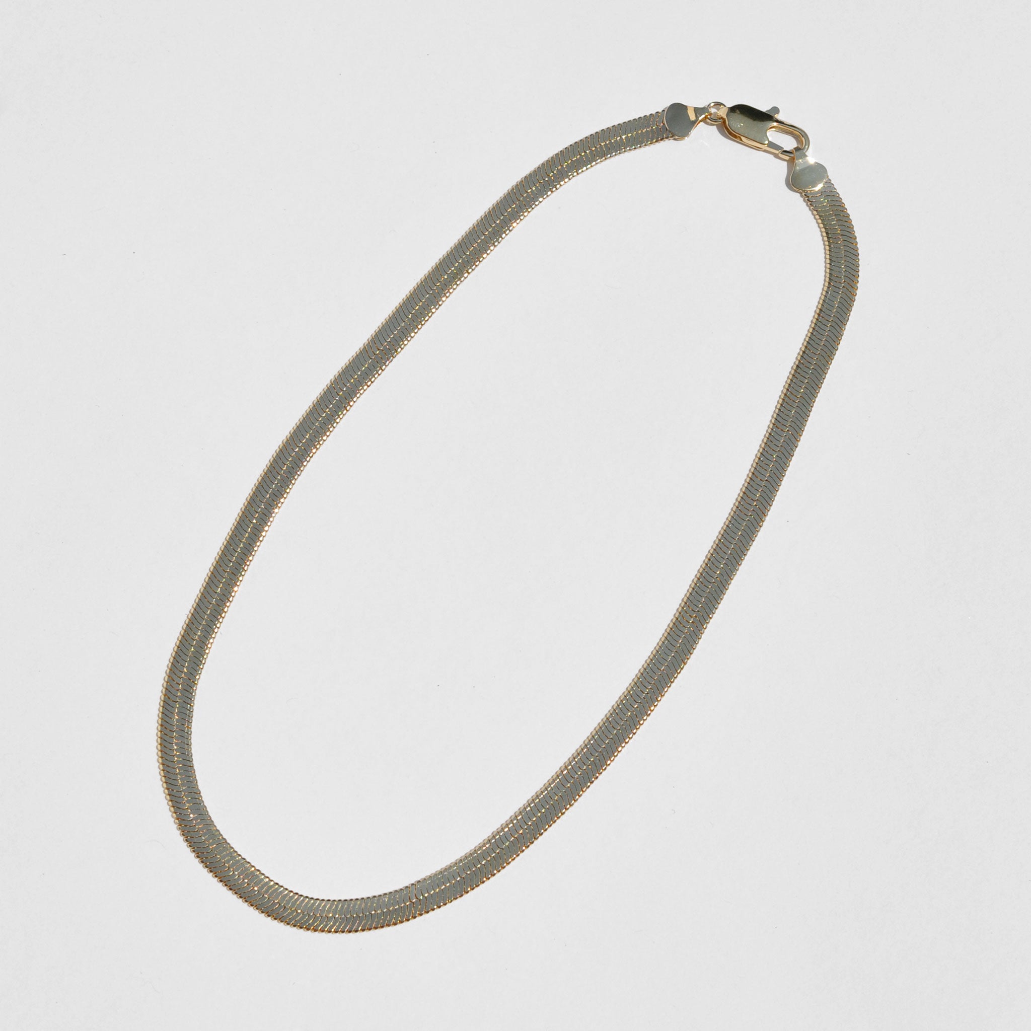 Shot of Laura Lombardi Omega Chain laid diagonal.