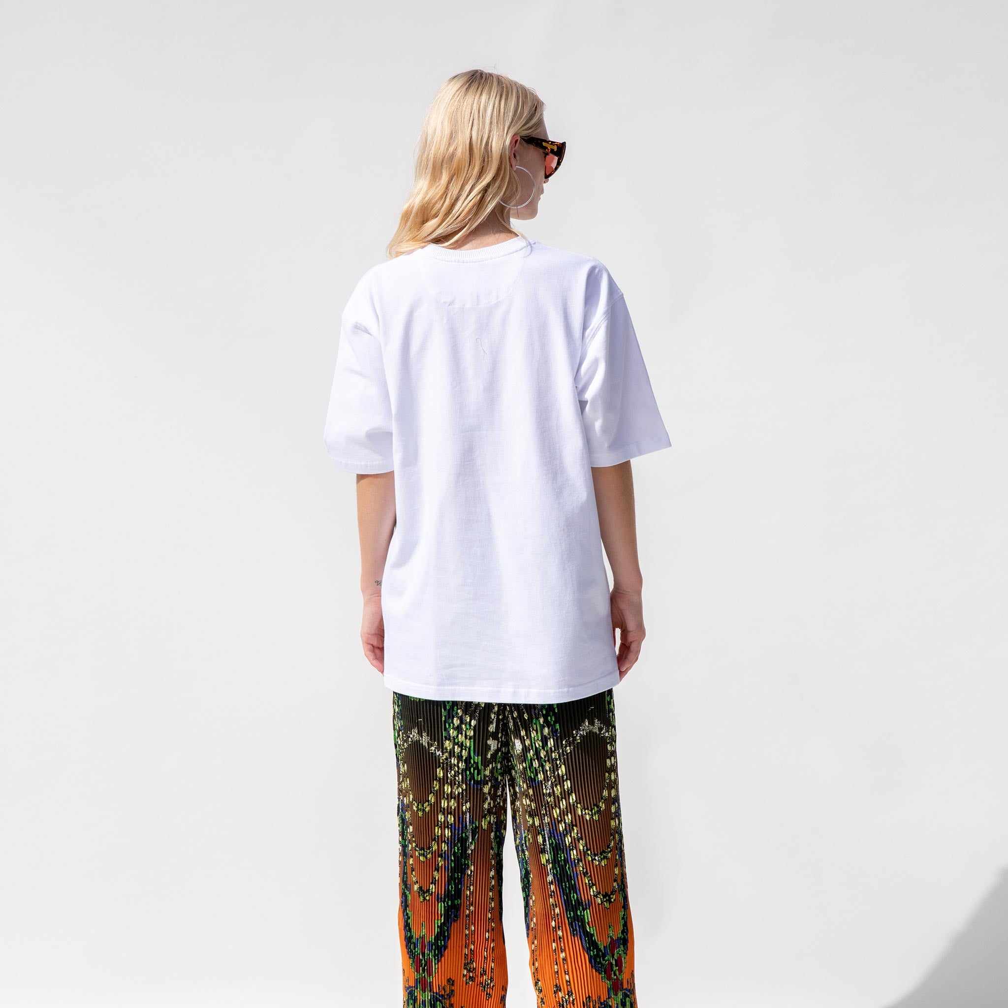 Back half body photo of model wearing the Link Tee - White.