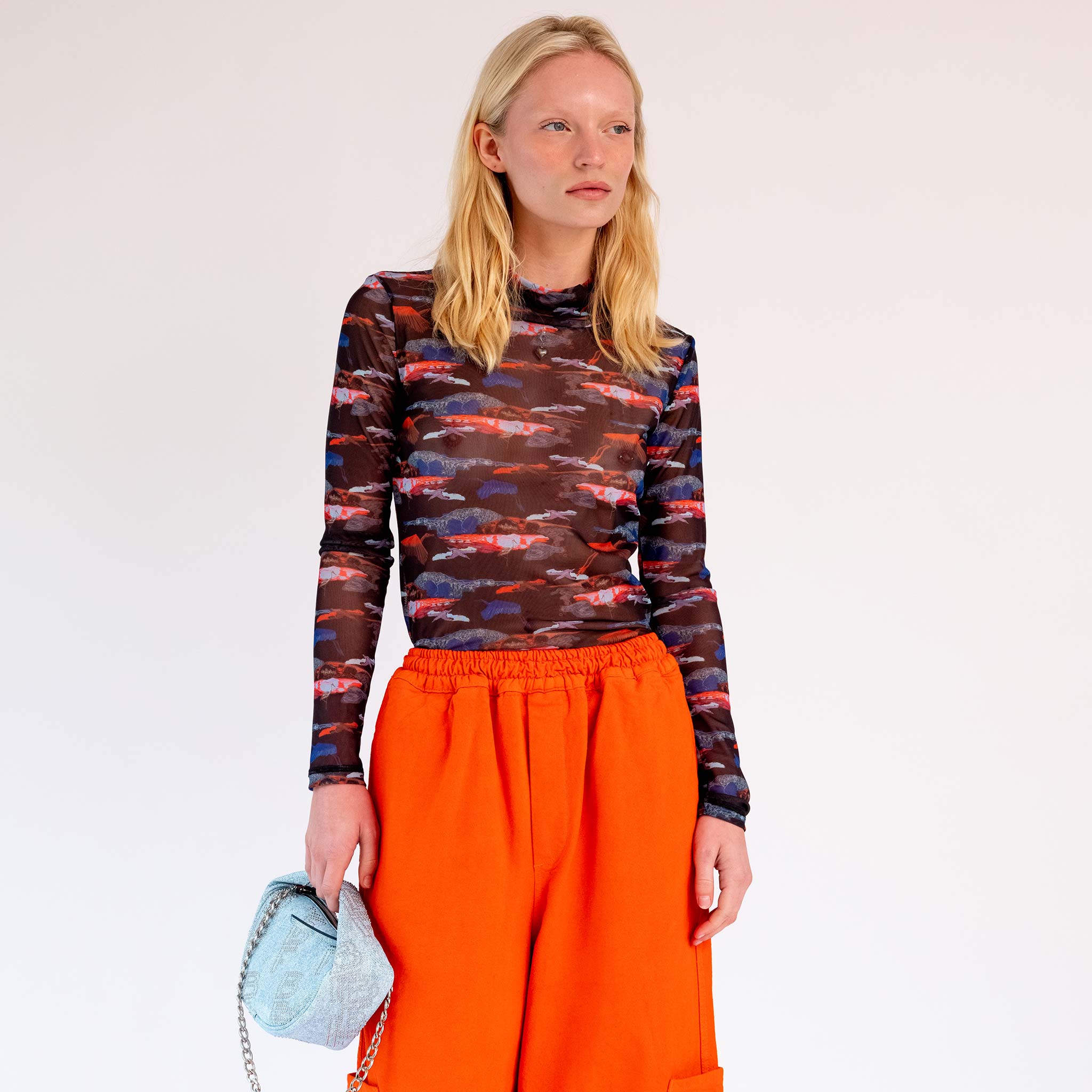 Close half body photo of model wearing the Mesh Turtleneck - Black Blue Birdie. 