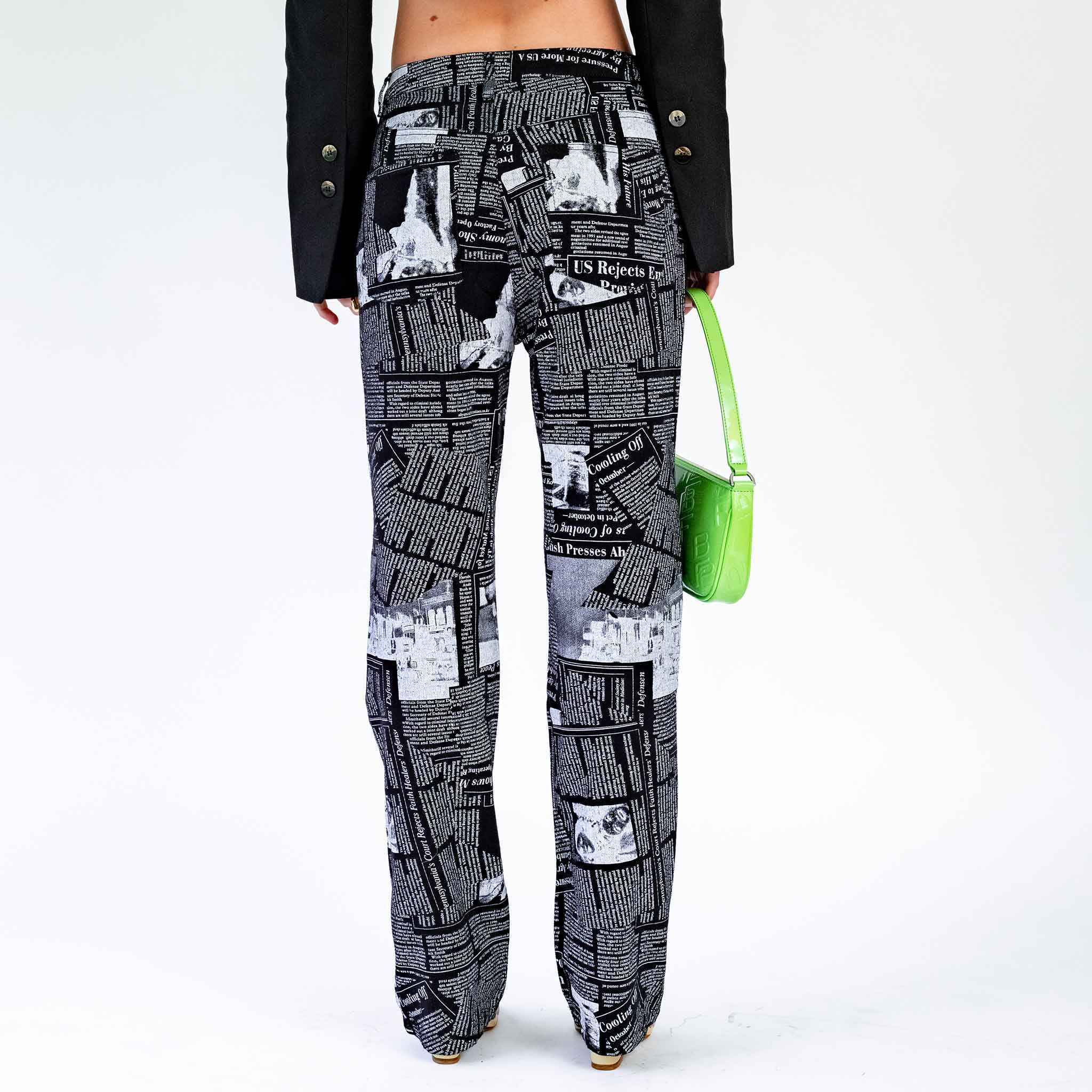 Back half body photo of model wearing the Newspaper Print Pocket Jeans - Black.
