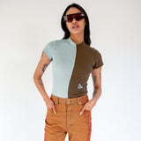 Front half body photo of model wearing the Oil and Water Split Neck Top - Blue Haze/Dark Olive.