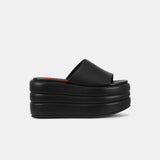 Side view of a black platform slide shoe in vegan leather.