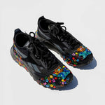 Top front view of the the collina strada black reebok sneaker with colorful painted flowers and a rhinestone toe clip. 