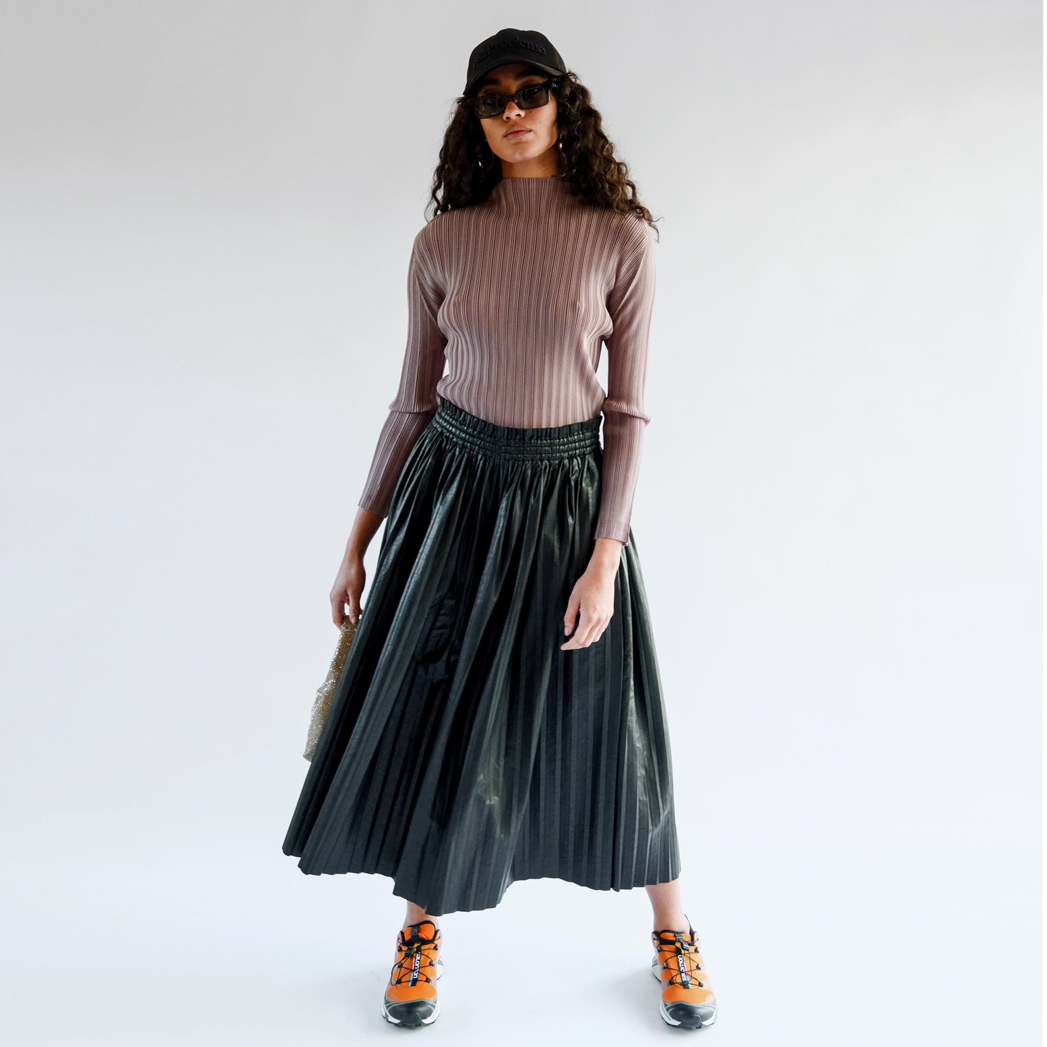 A model wears the mockneck ribbed turtleneck in a light mocha brown - full outfit view.