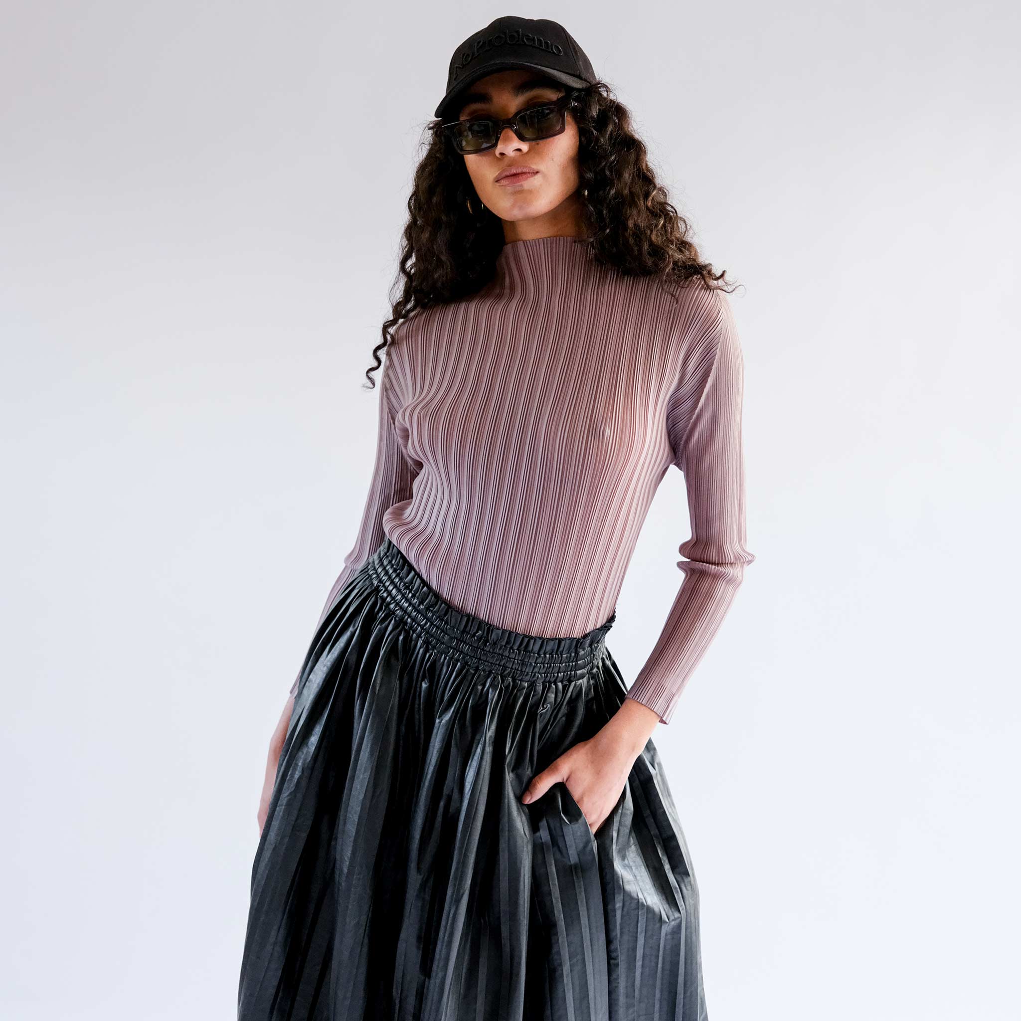 A model wears the mockneck ribbed turtleneck in a light mocha brown - front view.