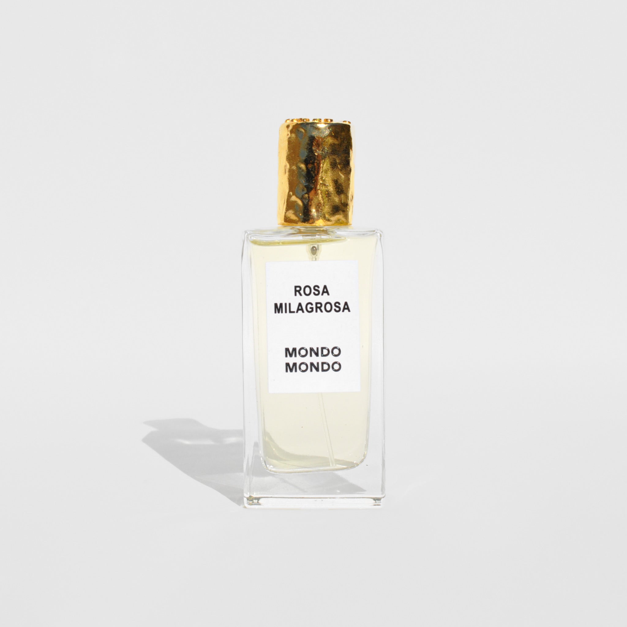Flat image of the rosa Milagrosa eau de perfum by Mondo Mondo. This perfume is off white with a gold top.