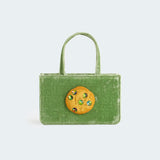 Small green velvet handbag with a lifelike cookie with jeweled chocolate chips on the front panel.
