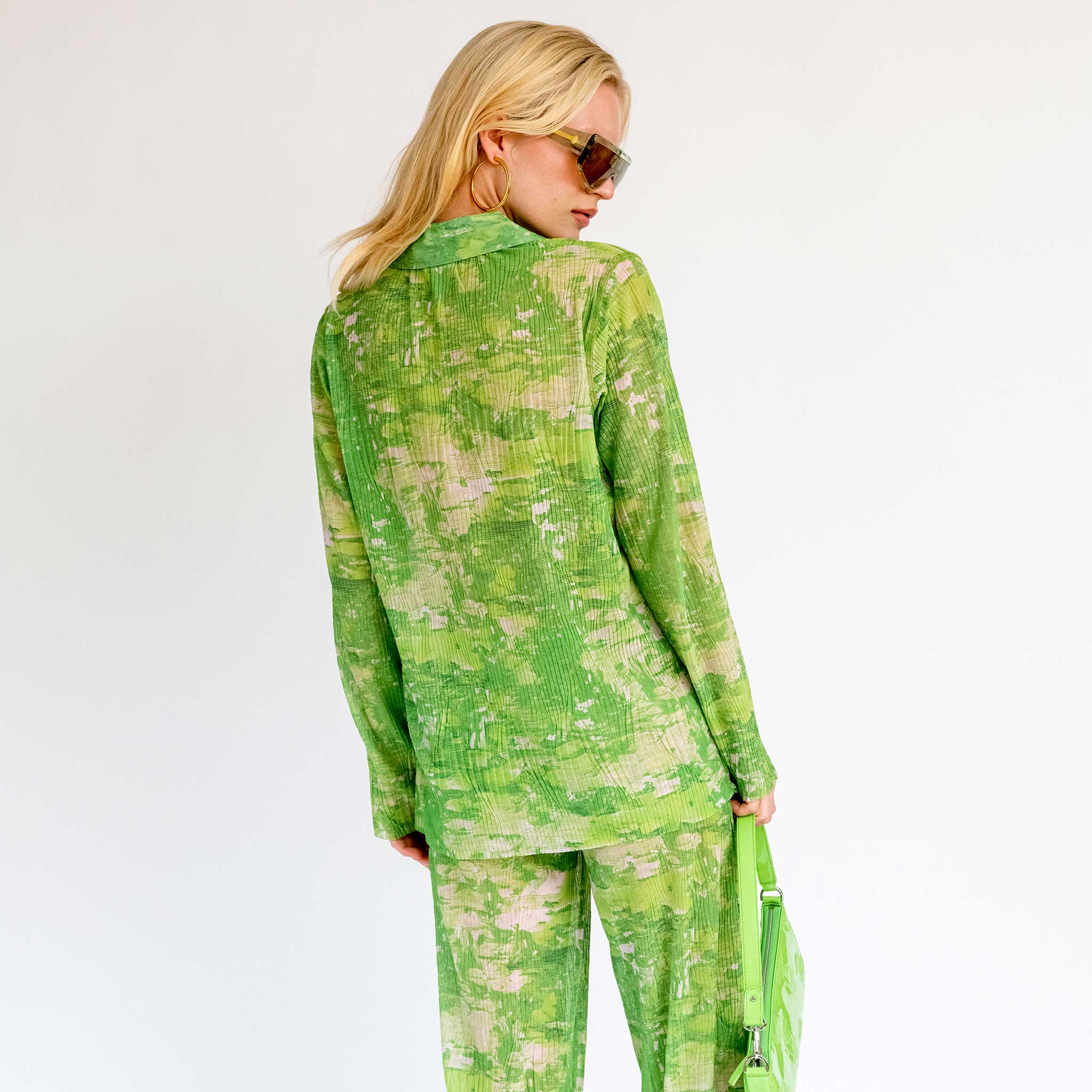 Back half body photo of model wearing the Short Mesh Plisse Shirt - Green Riddle.