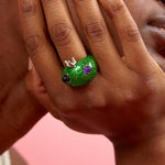 Green glittery Frog Ring by Collina Strada as worn on the hand.