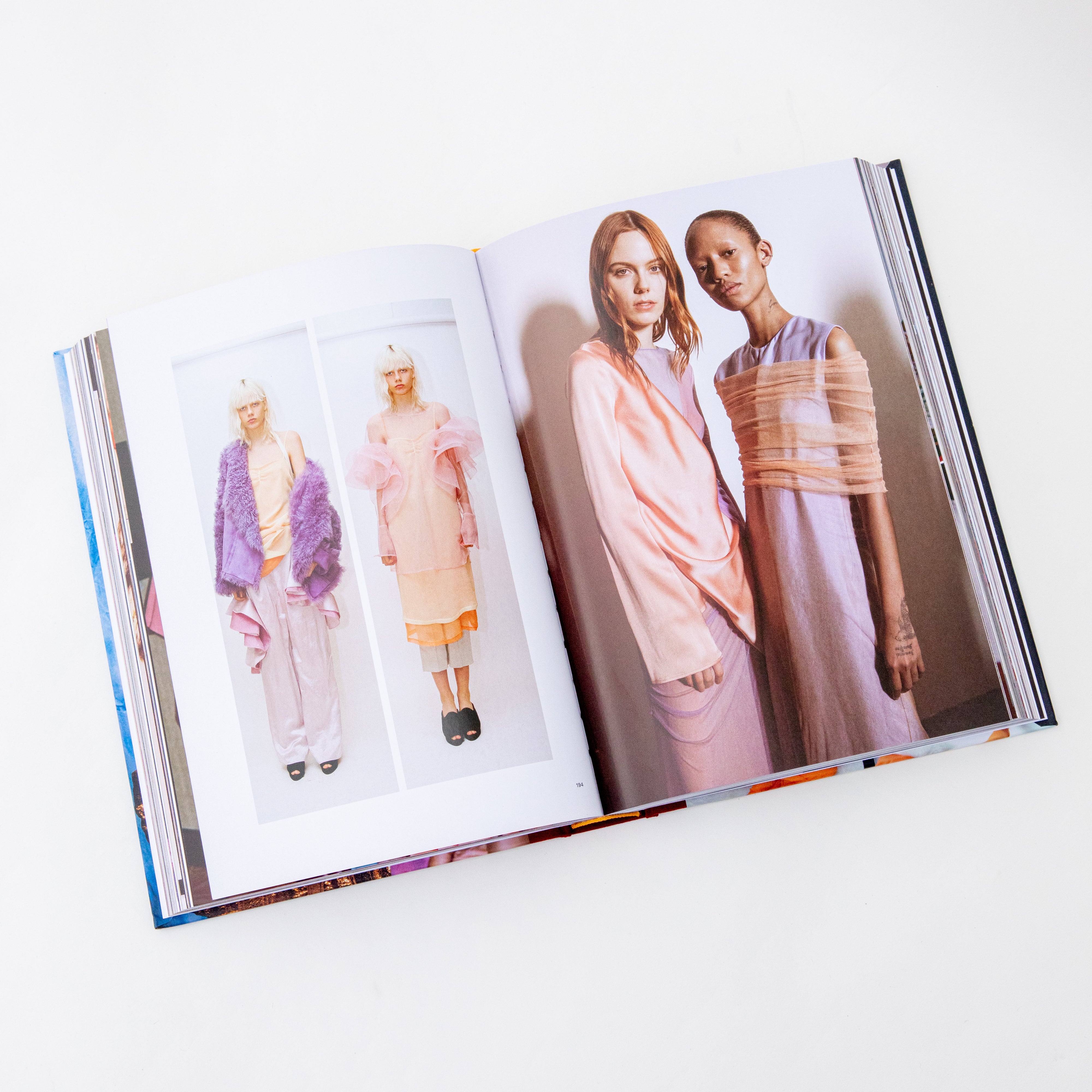 Photo of inside page of the Colors of Siew Marjan book. The page features models wrapped in various pastel fabrics. 