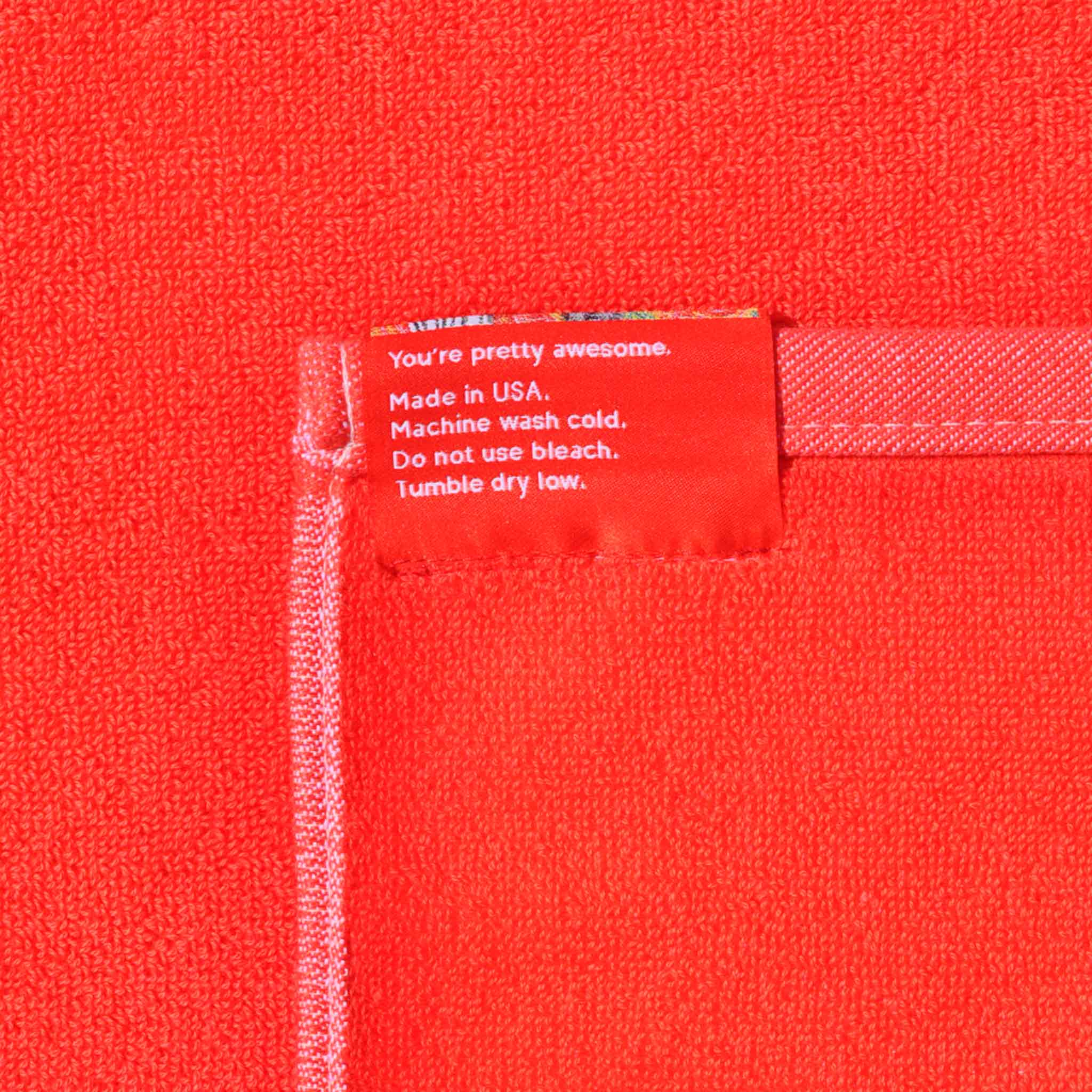 Close up image of the jacquard beach & bath towel in light red by LCD.