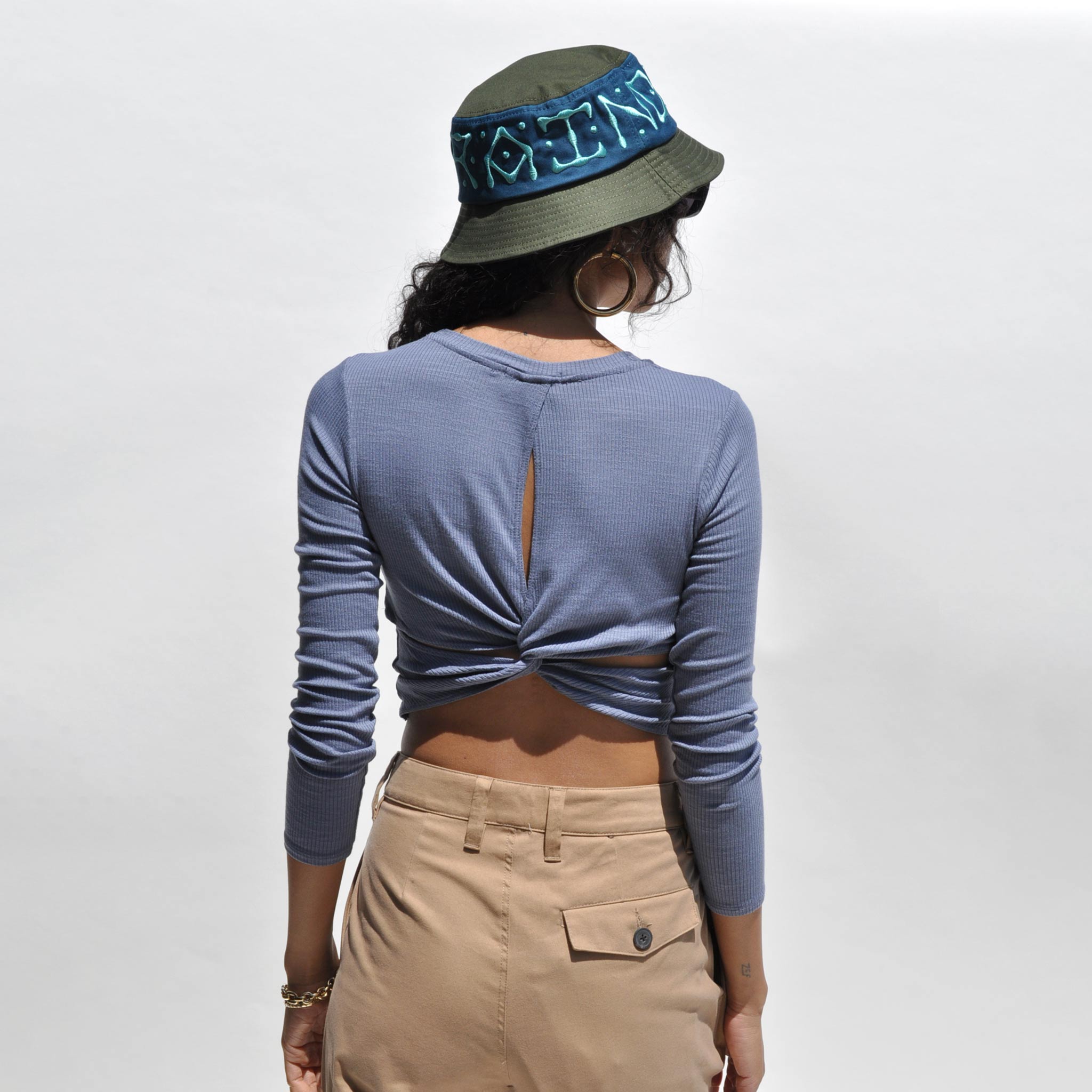 Back detail photo of model wearing the Twist Back Cropped Top in Slate Blue