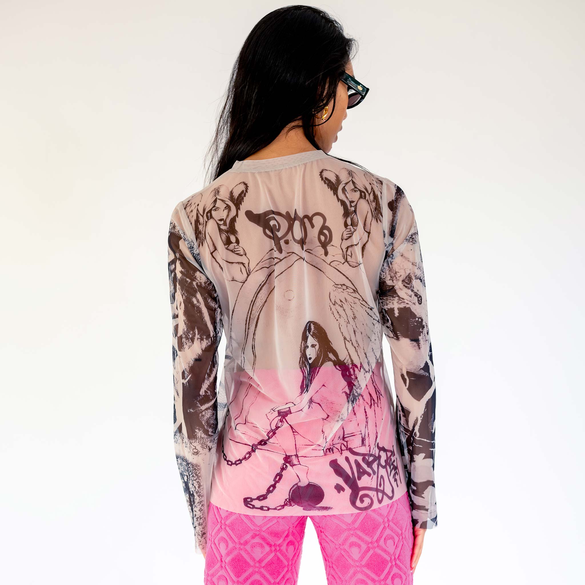 A model wears the semi-sheer Varg 2.0 Mesh Tattoo longsleeve unisex t-shirt with an elaborate all over graphic print inspired by tattoos, back view.