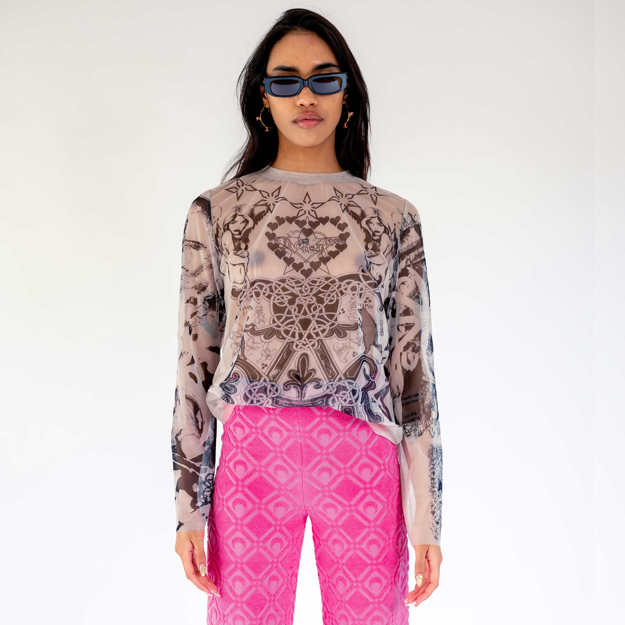 A model wears the semi-sheer Varg 2.0 Mesh Tattoo longsleeve unisex t-shirt with an elaborate all over graphic print inspired by tattoos, front view.