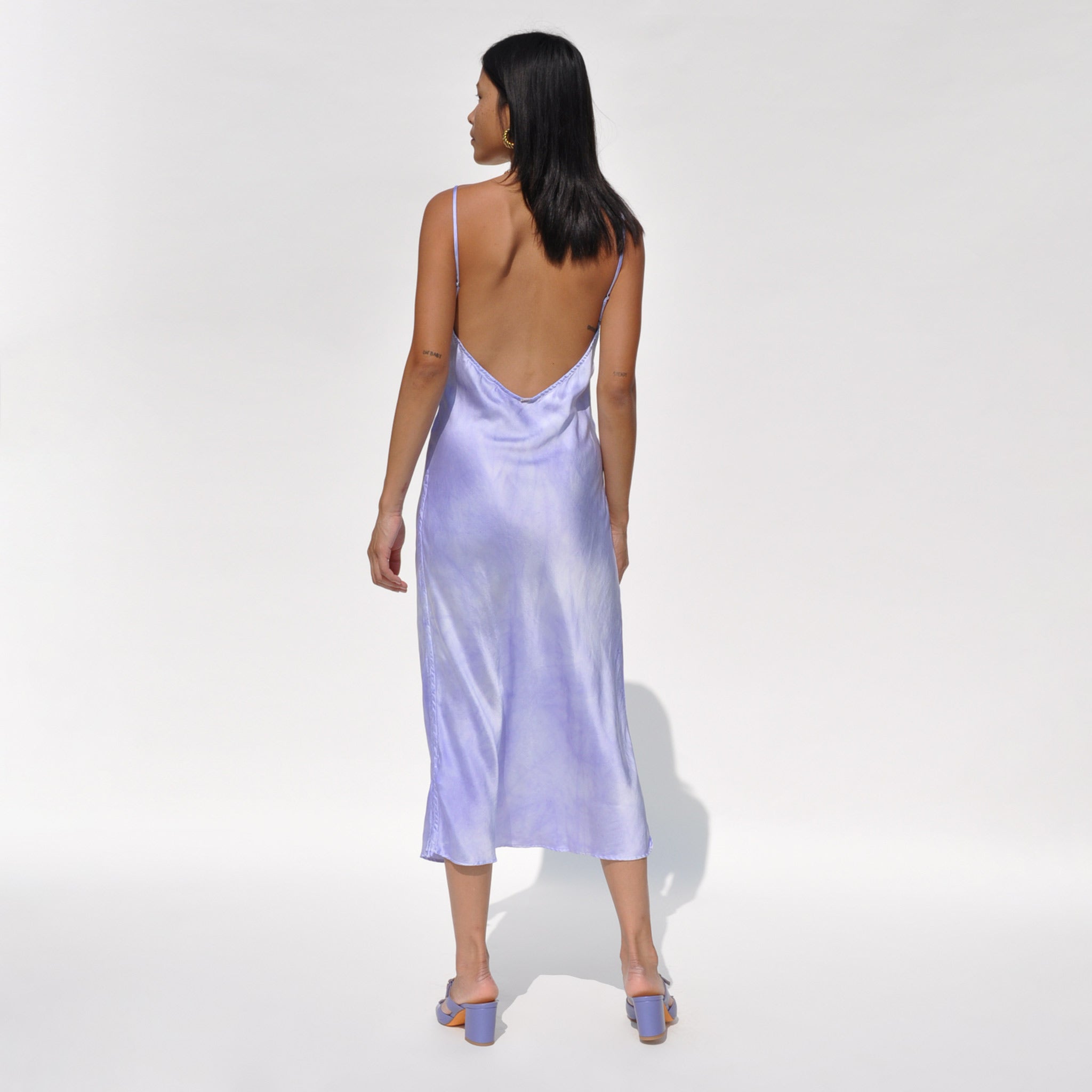 Back shot of a model wearing the vee midi slip dress in twilight by SVNR.