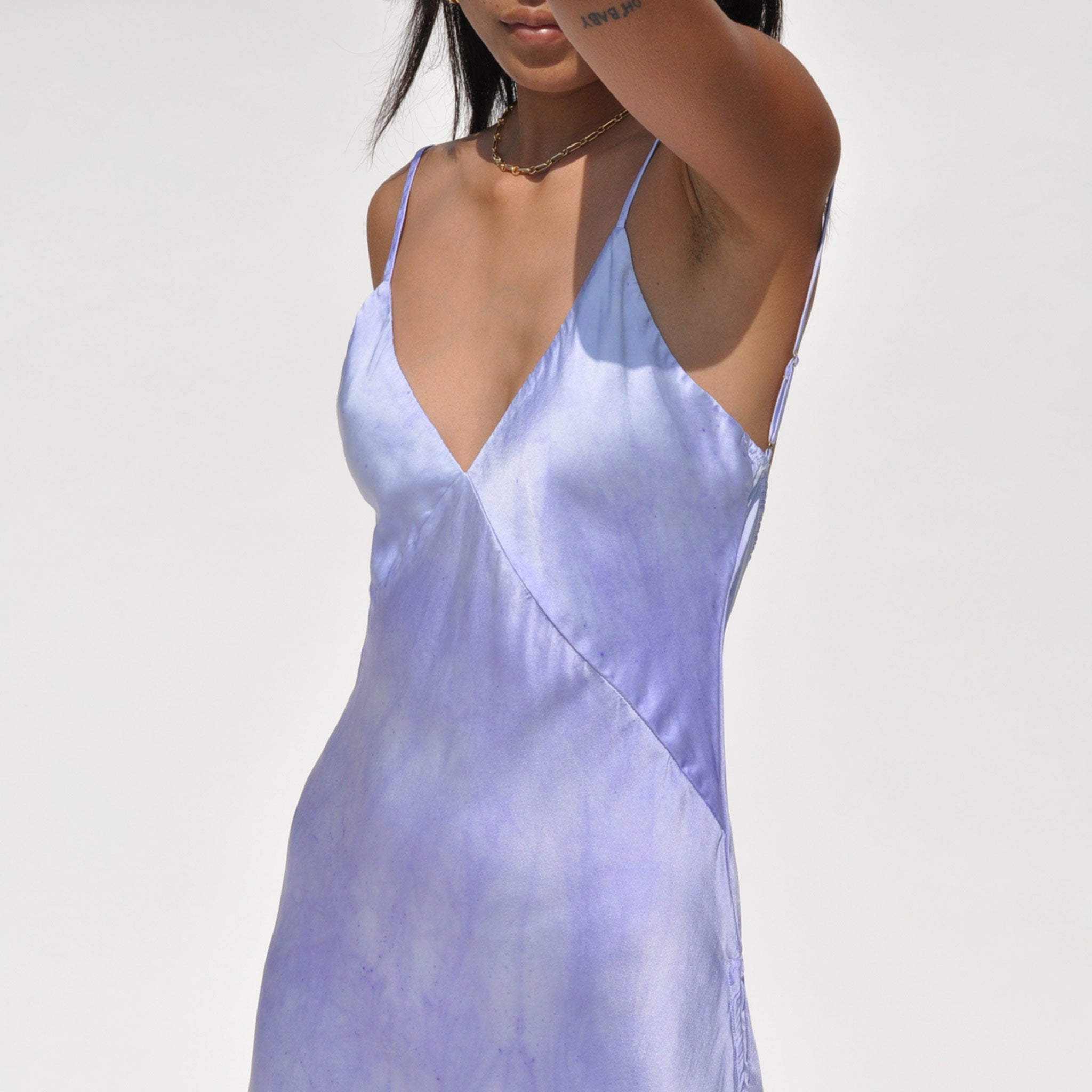 Close up shot of a model wearing the vee midi slip dress in twilight by SVNR.