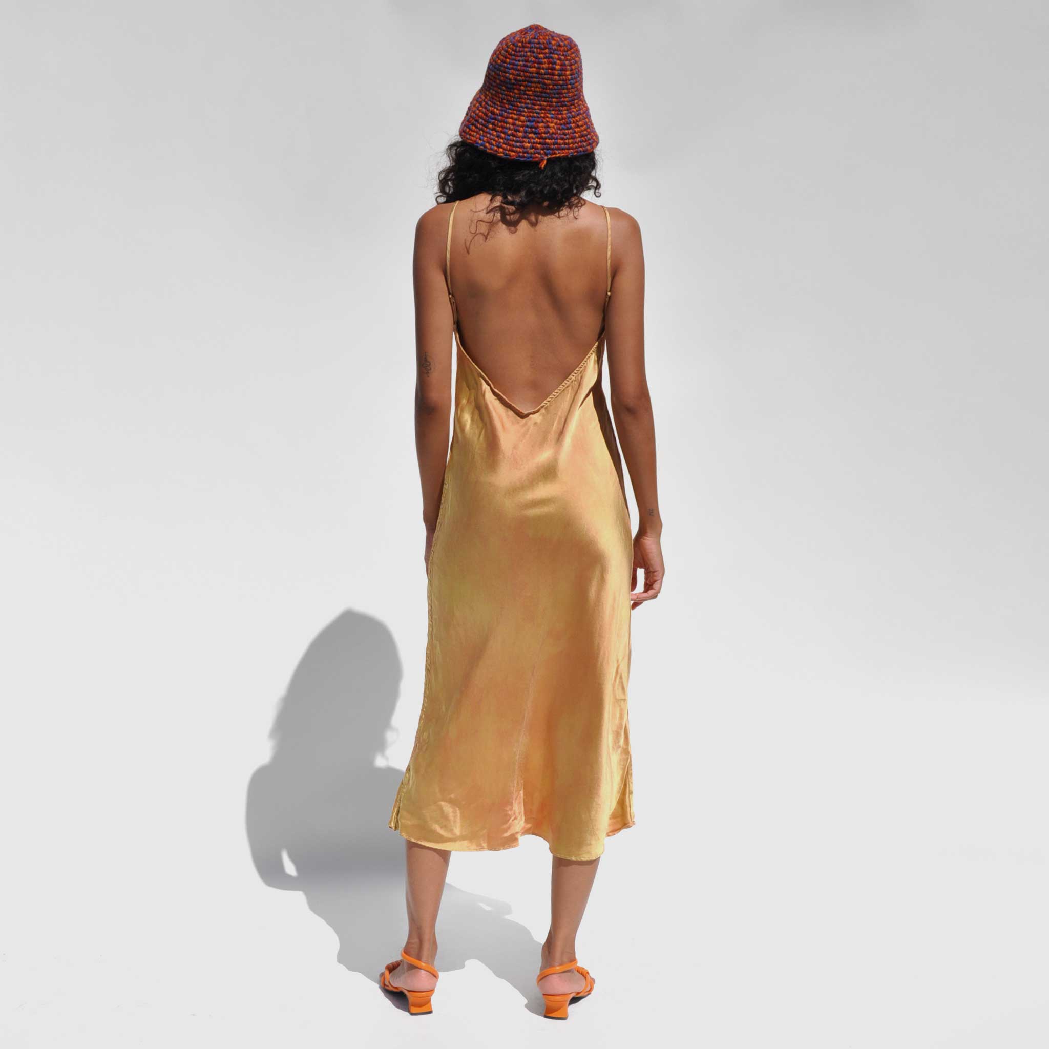 Back full body photo of model wearing the Vee Midi Slip Dress - Nude