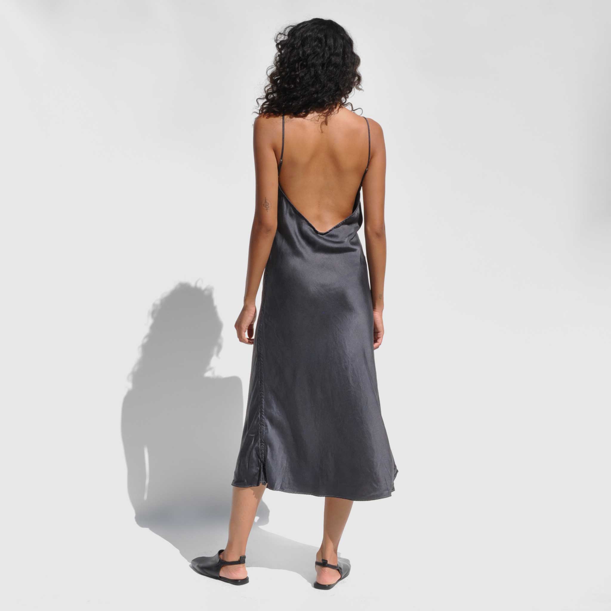 Back full body photo of model wearing the Vee Midi Slip Dress - Smoke