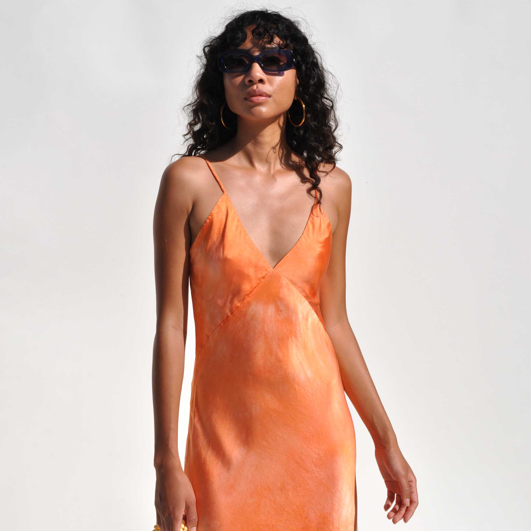 Clode detail photo of model wearing the Vee midi dlip dress in sunset