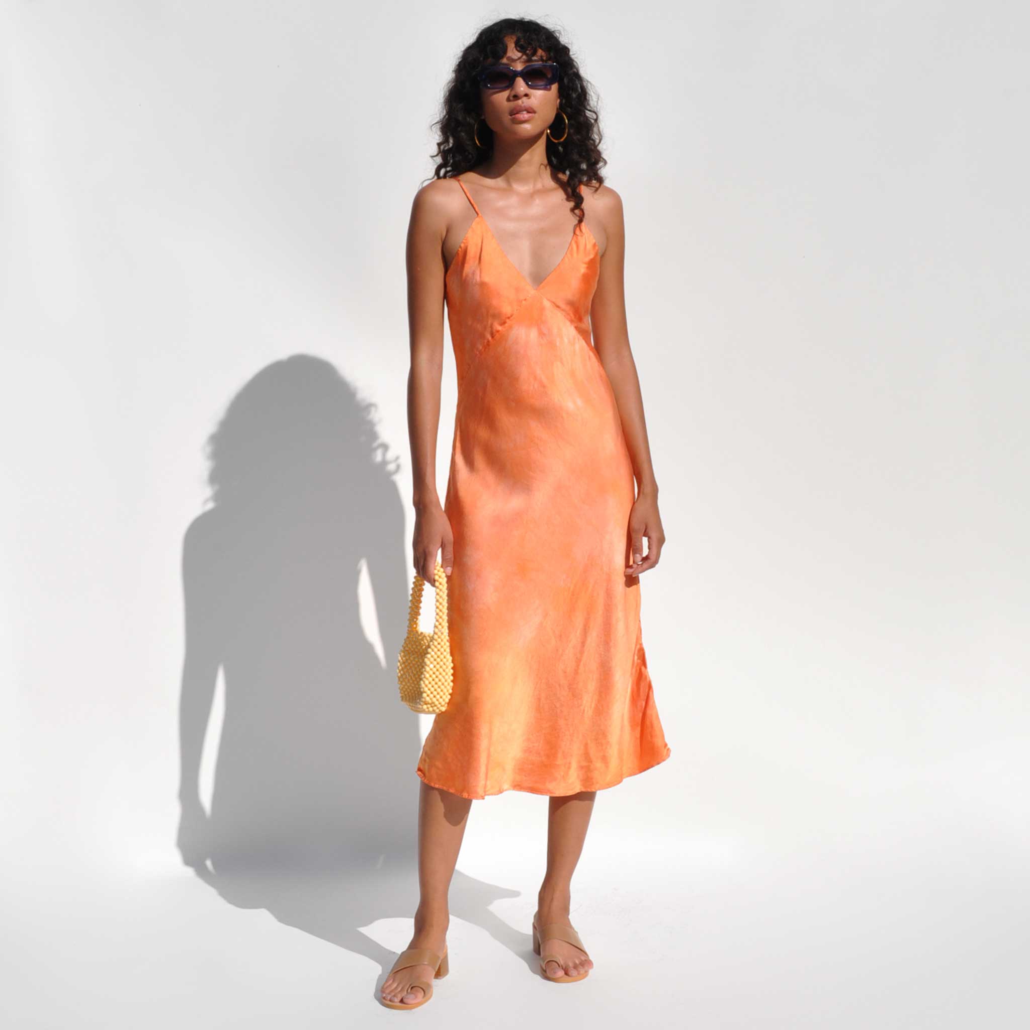 Front detail photo of model wearing the Vee Midi Slip Dress - Sunset