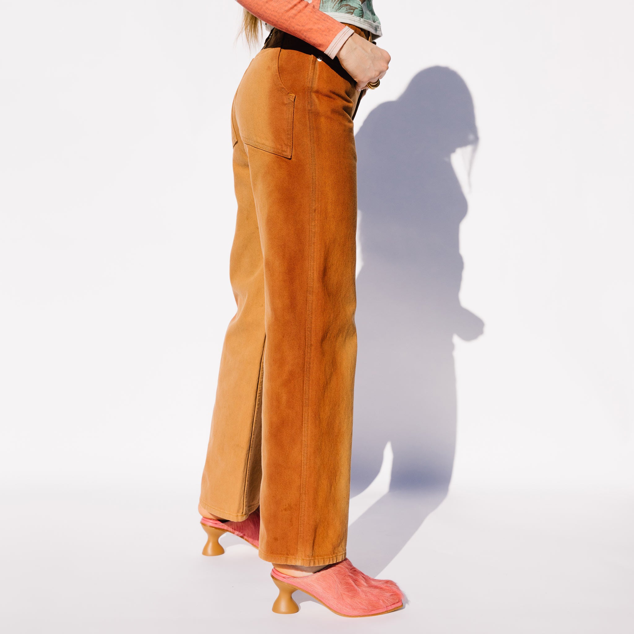 Side detail photo of model wearing the Wide Leg Jean - Terracota.
