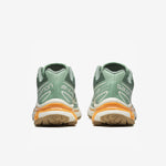 Salomon XT-6 sneakers in a pale green colorway with light orange trim along the sole. Back view.