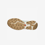 Salomon XT-6 sneakers in a pale green colorway with light orange trim along the sole. The sole.