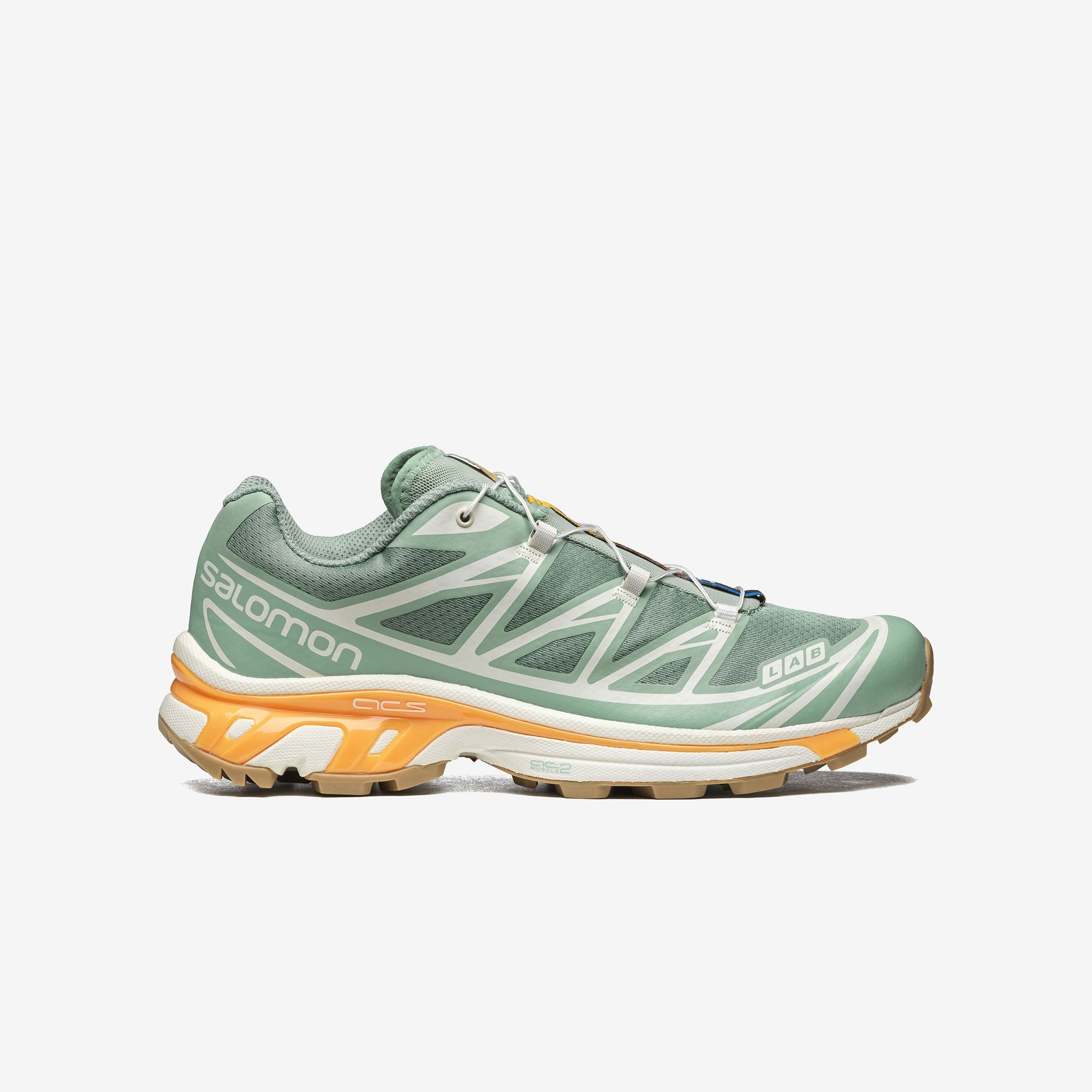 Salomon XT-6 sneakers in a pale green colorway with light orange trim along the sole. Side view.