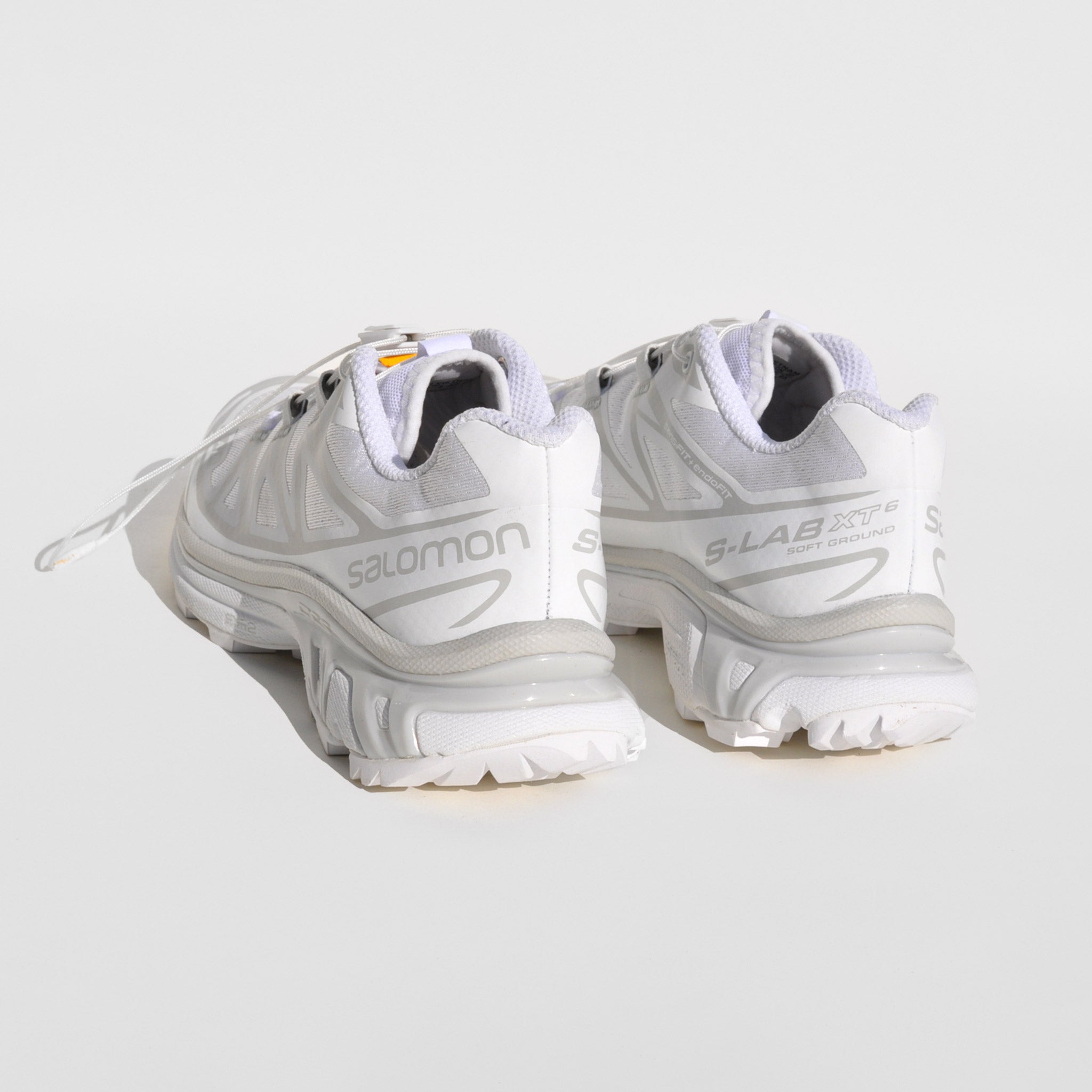 Back image of the XT-6-white sneakers by Salmon sport style in white. These sneakers are white with their rainbow logo down the middle tongue.