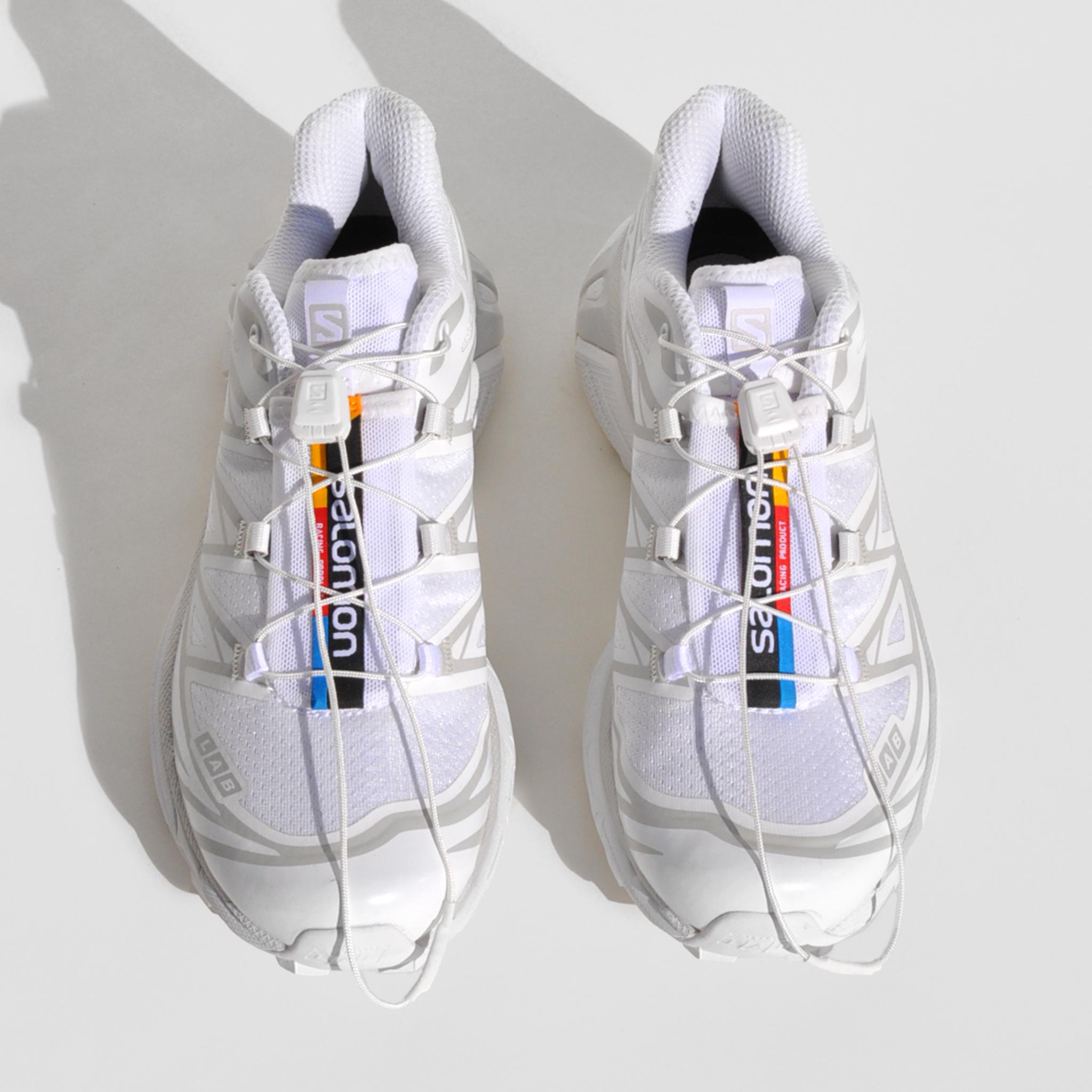 Above image of the XT-6-white sneakers by Salmon sport style in white. These sneakers are white with their rainbow logo down the middle tongue.